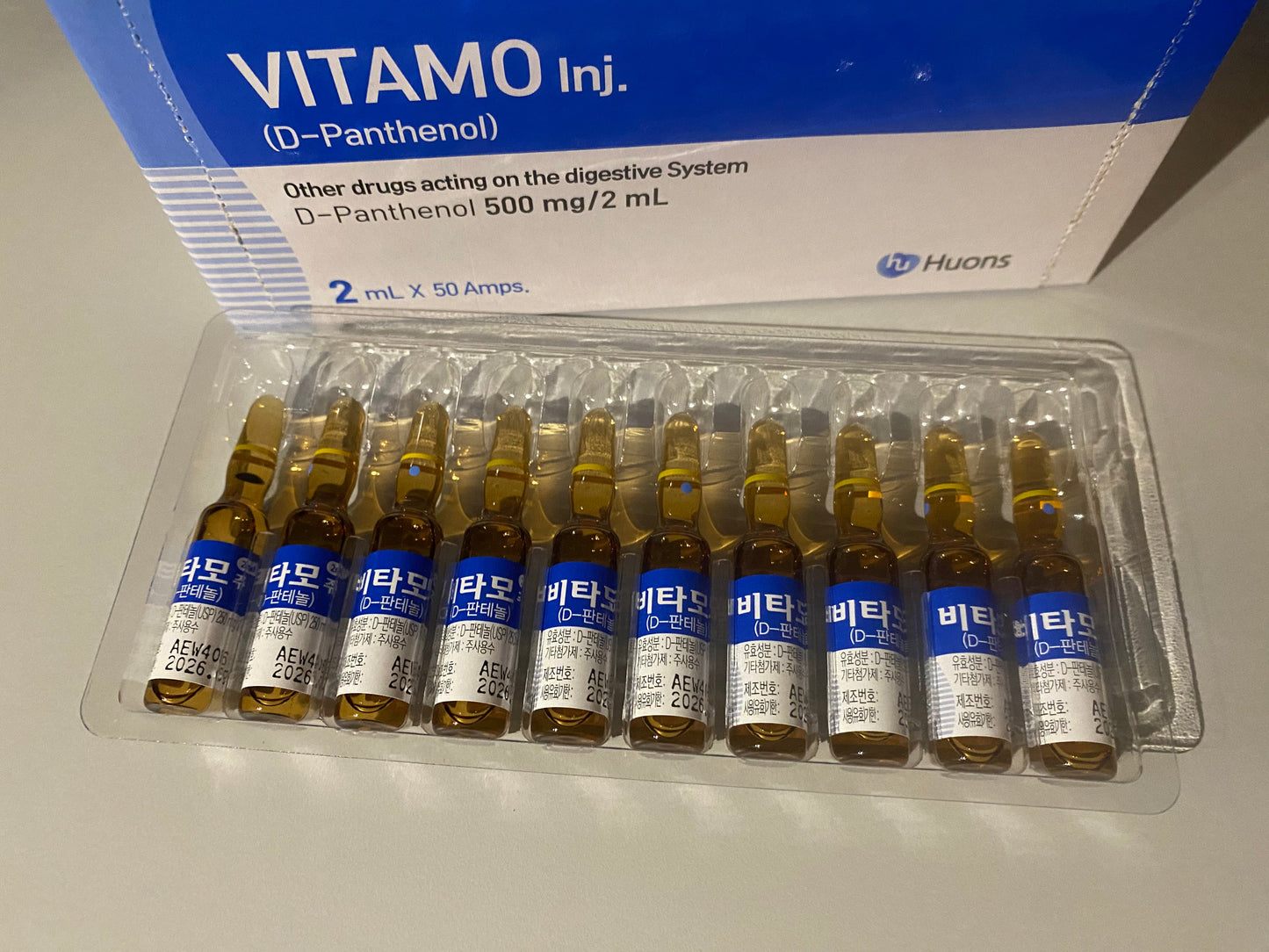 A box of VITAMO Inj. (D-Panthenol) with 50 amber ampoules, each 2 mL, visible in a tray.