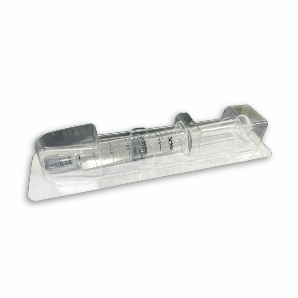A clear syringe with measurement markings is packaged in a clear plastic tray.