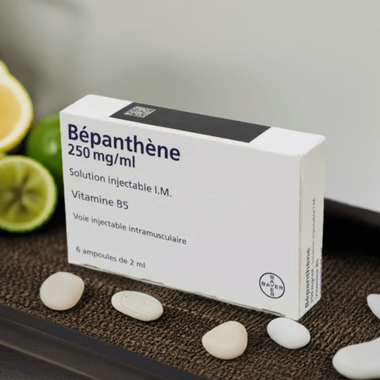 A white box of Bepanthene 250 mg/ml injectable solution with Vitamin B5, next to limes.