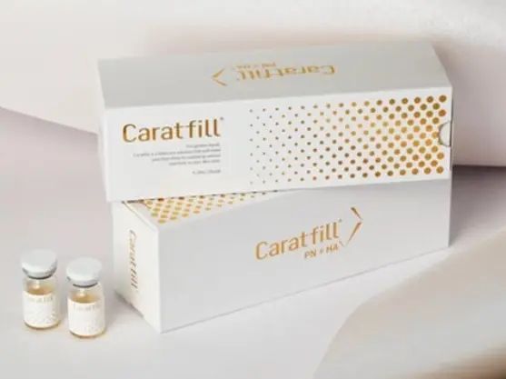 Two white boxes of Caratfill Skinbooster are stacked, with two small vials in front.