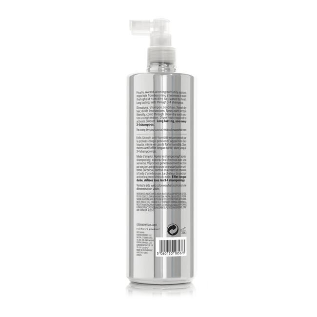 A silver spray bottle with a white pump top is shown from the back, displaying product information.