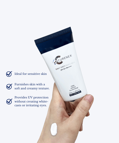 Curenex Daily Sheer Sunscreen tube held in a hand with a dab of cream.